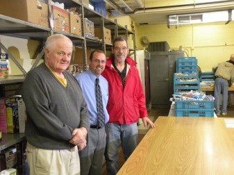 Jim Christie, executive director of The Franciscan Center, center, poses with food pantry volunteers John Matera, left, and Dave Sensenich, right, on Nov. 5. The food pantry operates Tuesdays and Thursdays from 9-11 a.m. in the basement of the Sacred Heart School in Fort Wayne at 4643 Gaywood Dr.