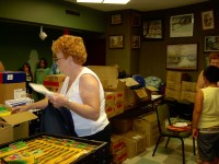 Mary Muzzillo fills backpack with school supplies for a child in need. 