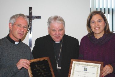 Karen Clifford Bishop John M. D’Arcy, center, congratulates St. Pius X Pastor Father Bill Schooler and Betsy Quinn, St. Pius X director of evangelization and stewardship, on the parish’s selection as runner-up for the Archbishop Thomas J. Murphy Award.