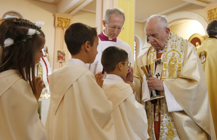 After offering instruction, pope gives first Communion to 245 children